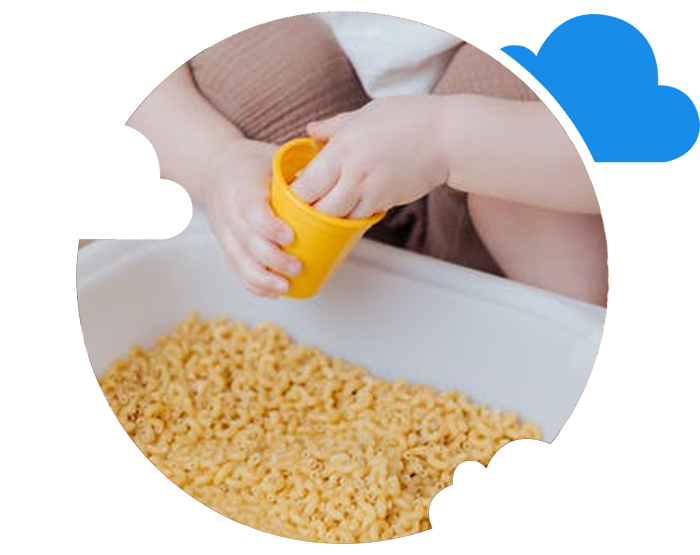 Baby playing with macaroni